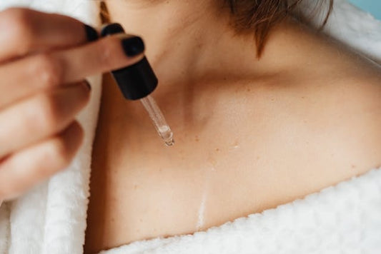 Woman applying oil to decolletage